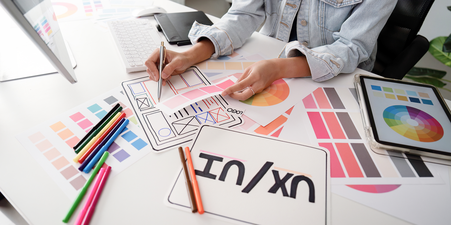 Webサイト制作におけるUIデザインとはのポイントを整理するため、UI/UXやデザイン紙を広げている様子